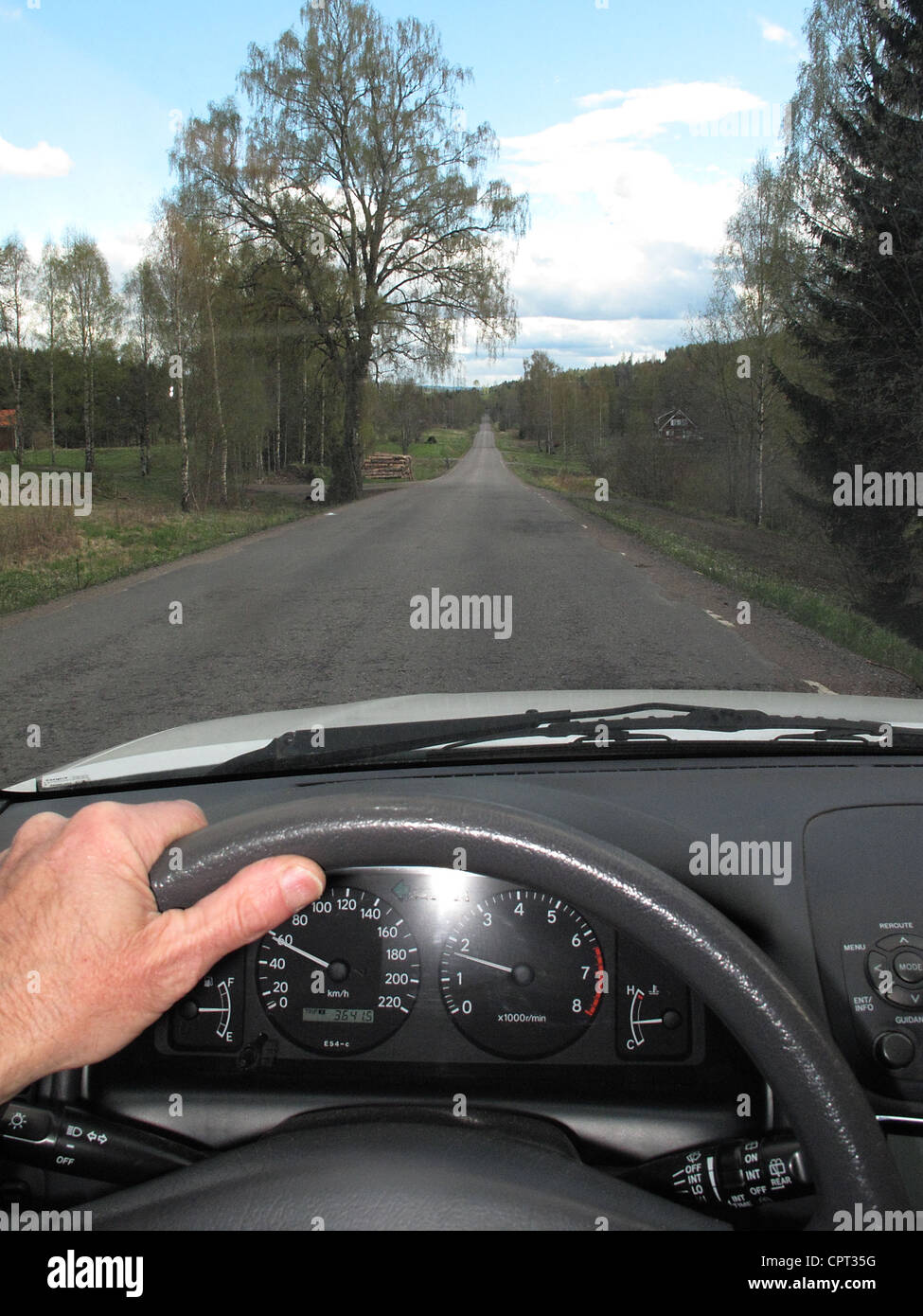 Vista guidatore attraverso il parabrezza su un vuoto e stretto country road Foto Stock