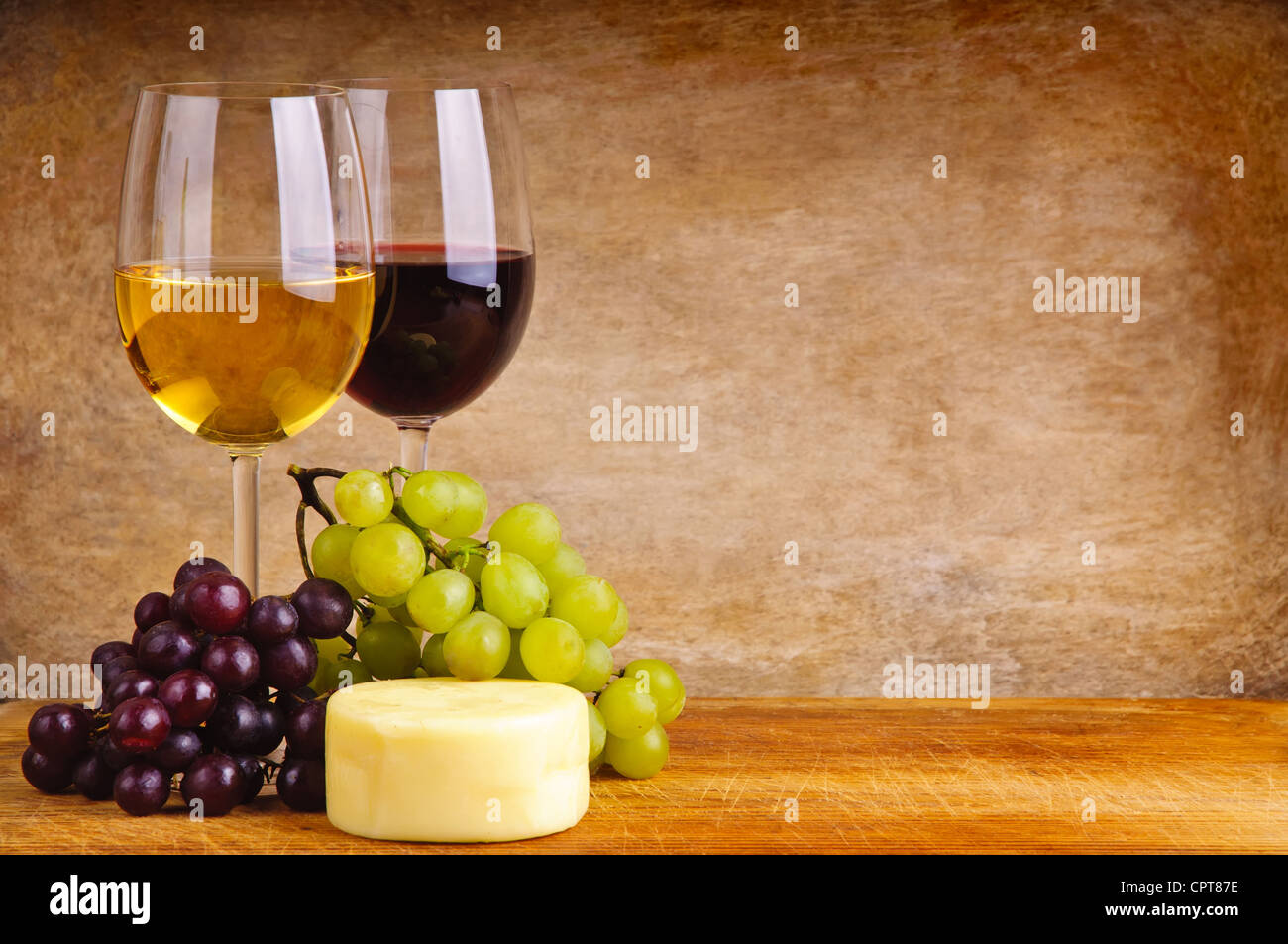 Ancora vita composizione con un bicchiere di vino rosso e bianco, formaggio e Uva su uno sfondo di legno con una copia in formato testo space Foto Stock