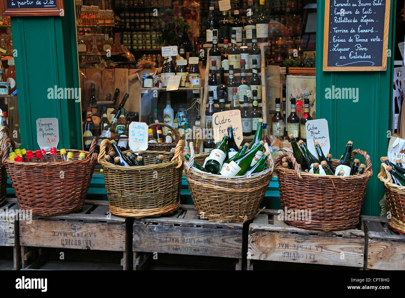 Cestini di varie sidri e brandy locali al di fuori di un negozio in Honfleur, Normandia Foto Stock