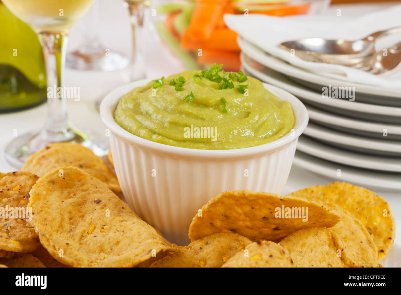 Guacamole e rabboccato con fresco peperoncino verde con corn chips per immersione, fissati su un tavolo da buffet. Foto Stock