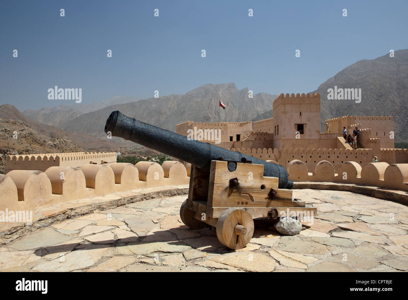Vecchio canonico sulla sommità del Nakhl Fort, circondato da montagne Hajar (Al Batinah, Oman) Foto Stock