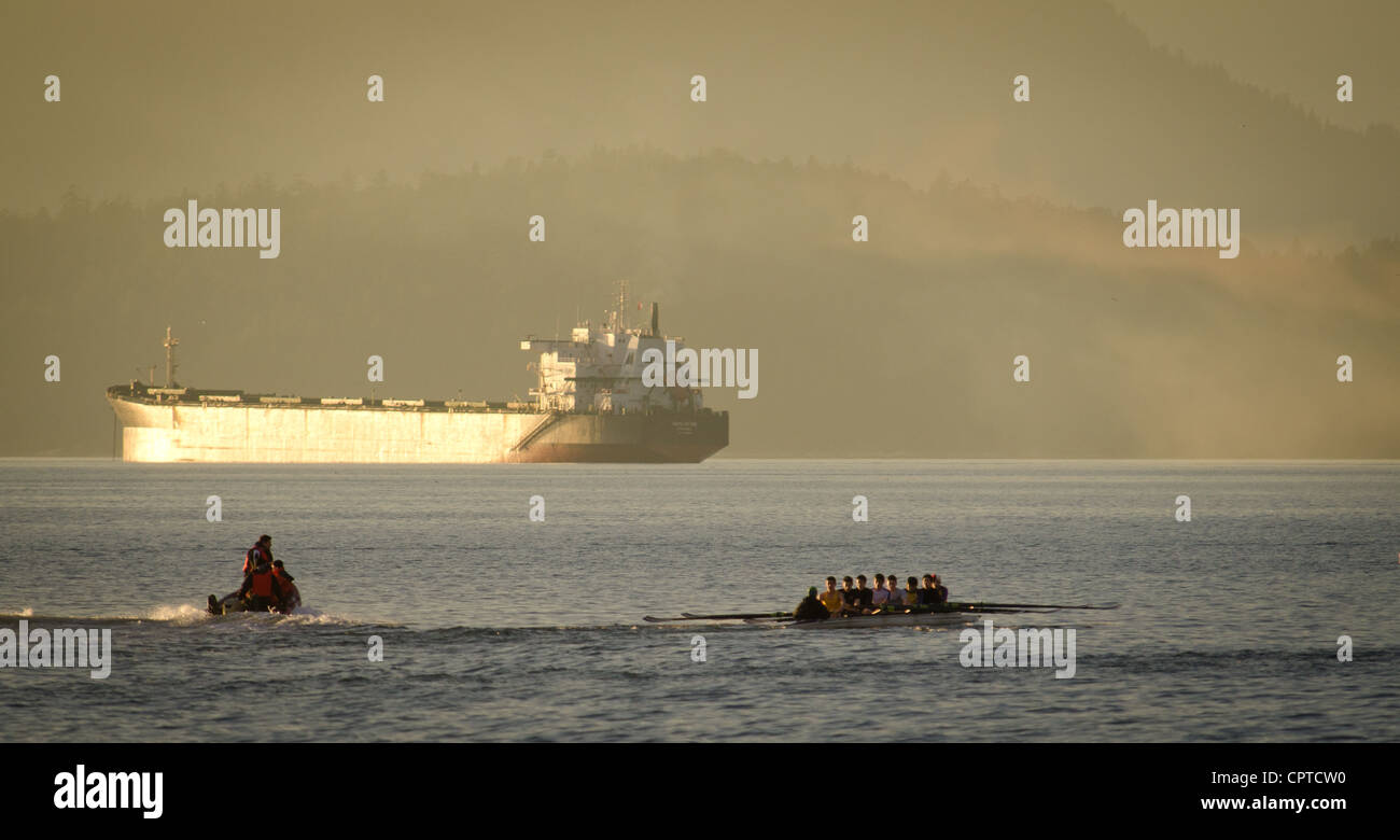 Formazione di canottaggio di fronte KAYU EBONI portarinfuse che sono ancorate al largo di Vancouver, BC, Canada Foto Stock