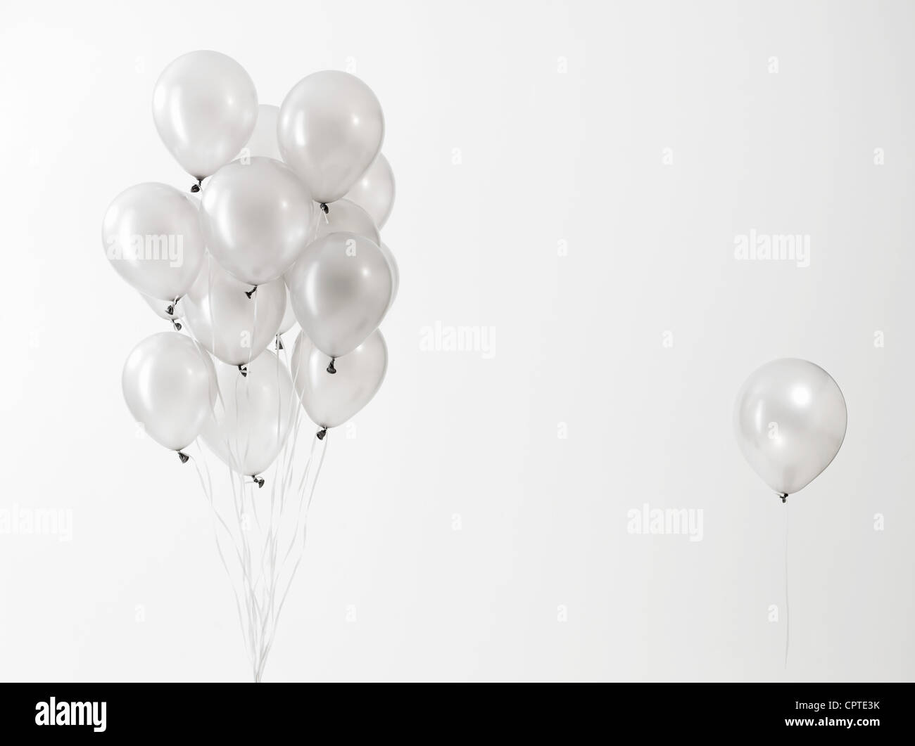 Palloncini argentati floating contro uno sfondo bianco Foto Stock