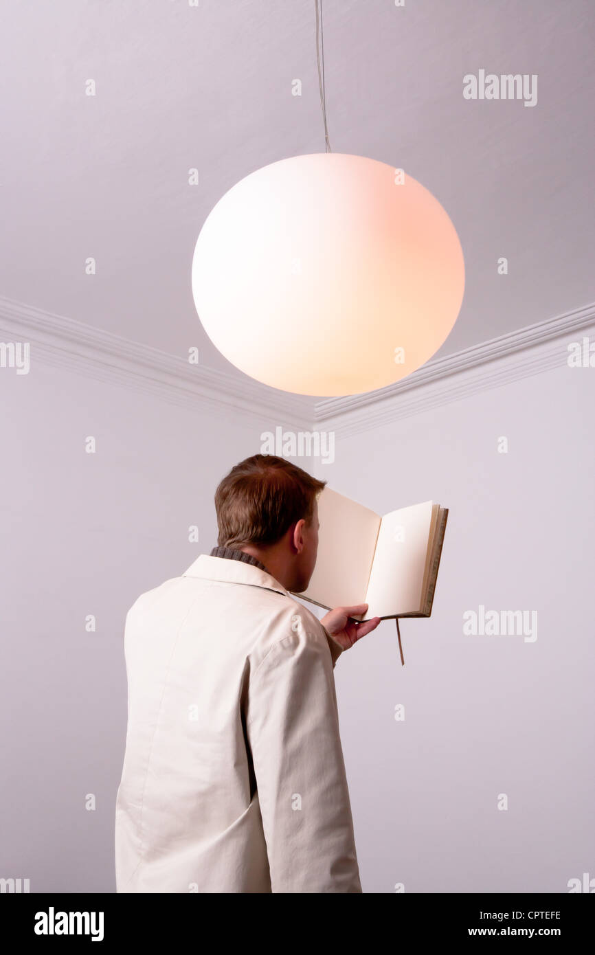 Uomo di lettura del libro bianco Foto Stock