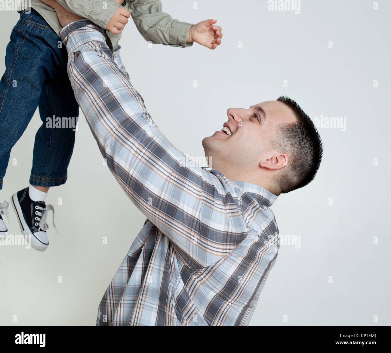 Il giovane figlio di contenimento in aria, studio shot Foto Stock