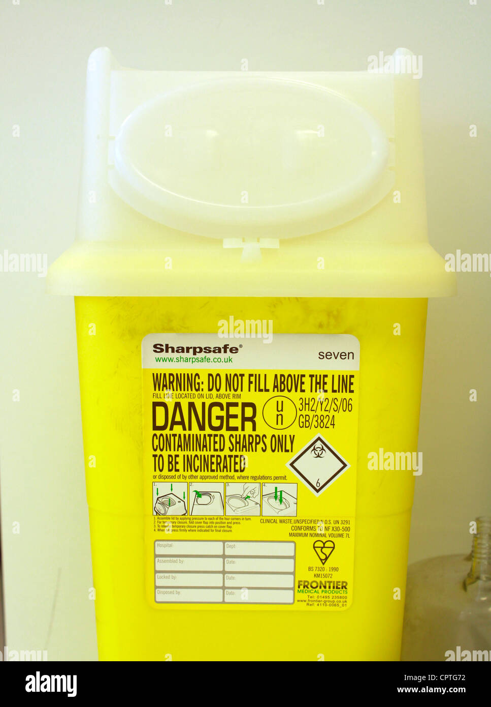 Simbolo giallo di avvertimento su un bidone della spazzatura in un laboratorio Foto Stock