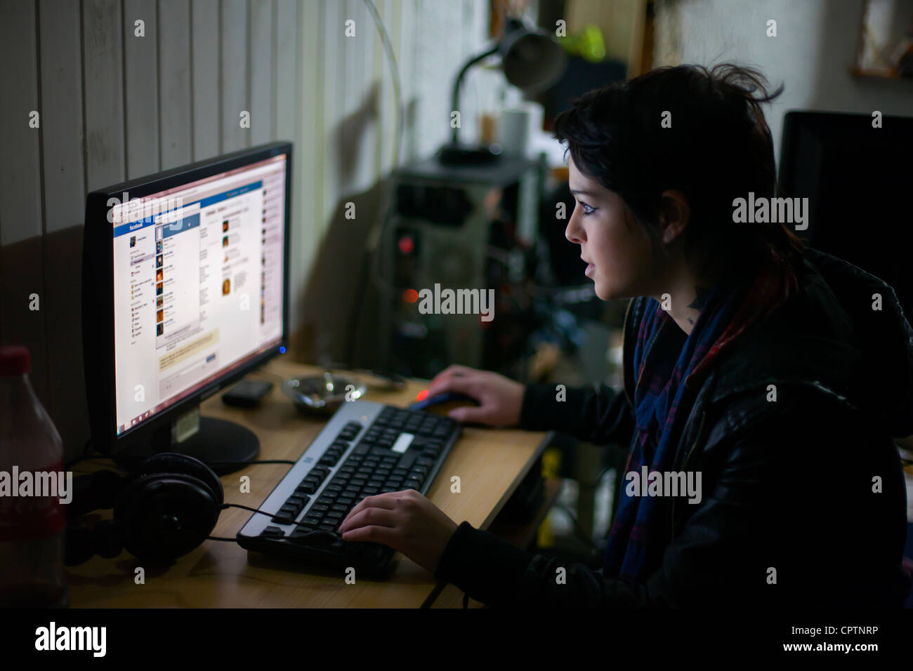 Giovane donna controllando il suo facebook sul computer. Foto Stock