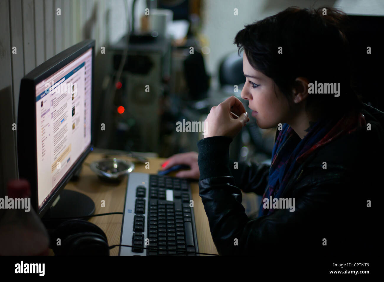 Giovane donna controllando il suo facebook sul computer.. Foto Stock