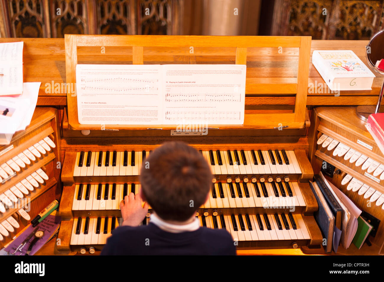 Un dodicenne ragazzo giocando un organo da chiesa con il punto di messa a fuoco sulla musica nel Regno Unito Foto Stock