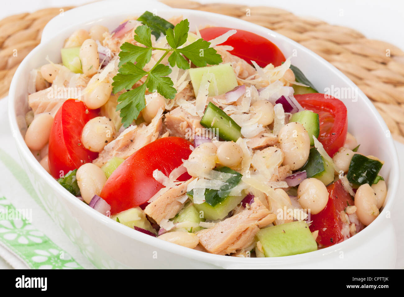 Italian cannelini bean e insalata di tonno, con il cetriolo, pomodoro, cipolla rossa, il parmigiano e un aglio vinaigrette dressing. Foto Stock