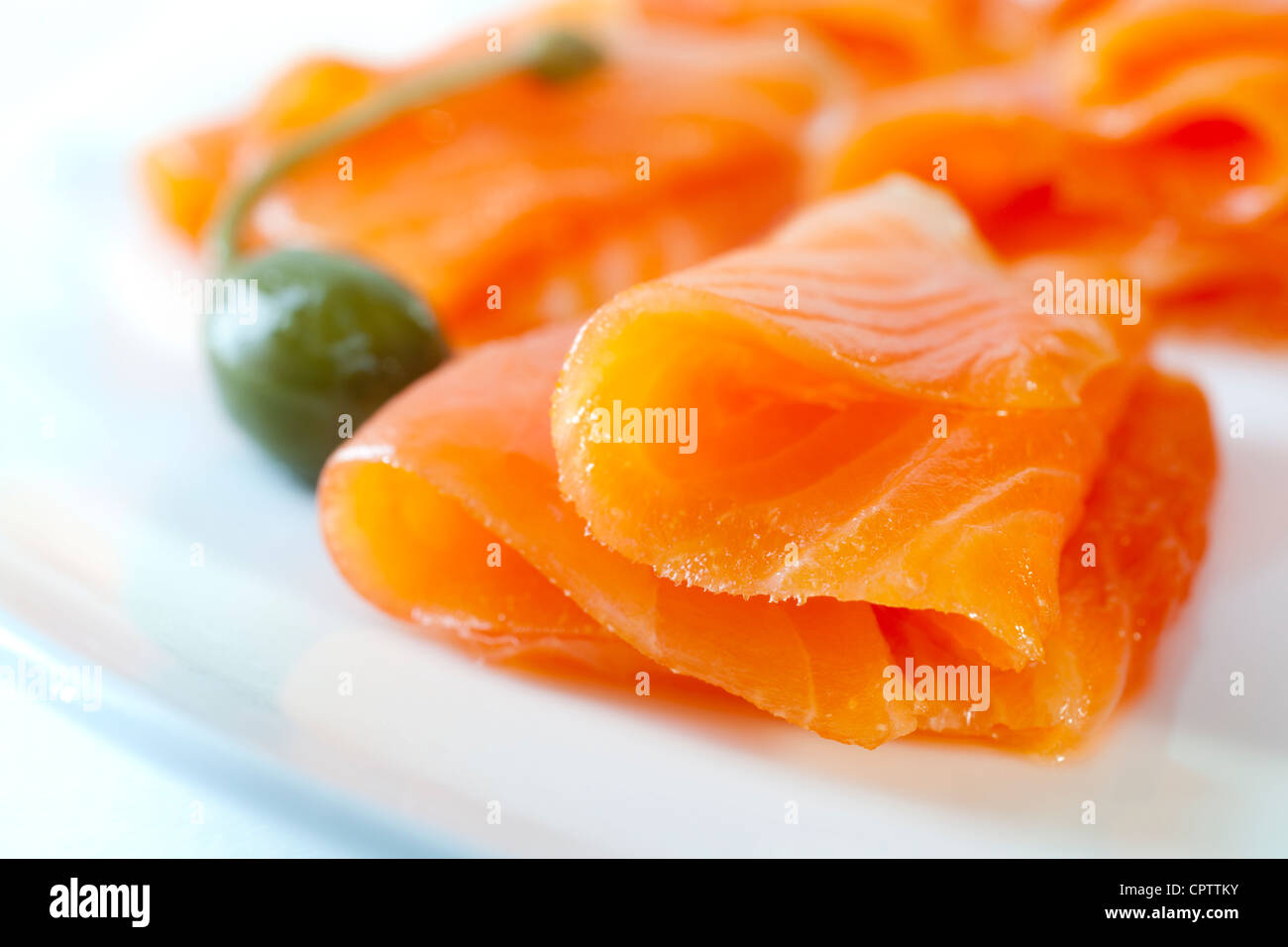 Il freddo salmone affumicato su una piastra bianca con un caperberry Foto Stock