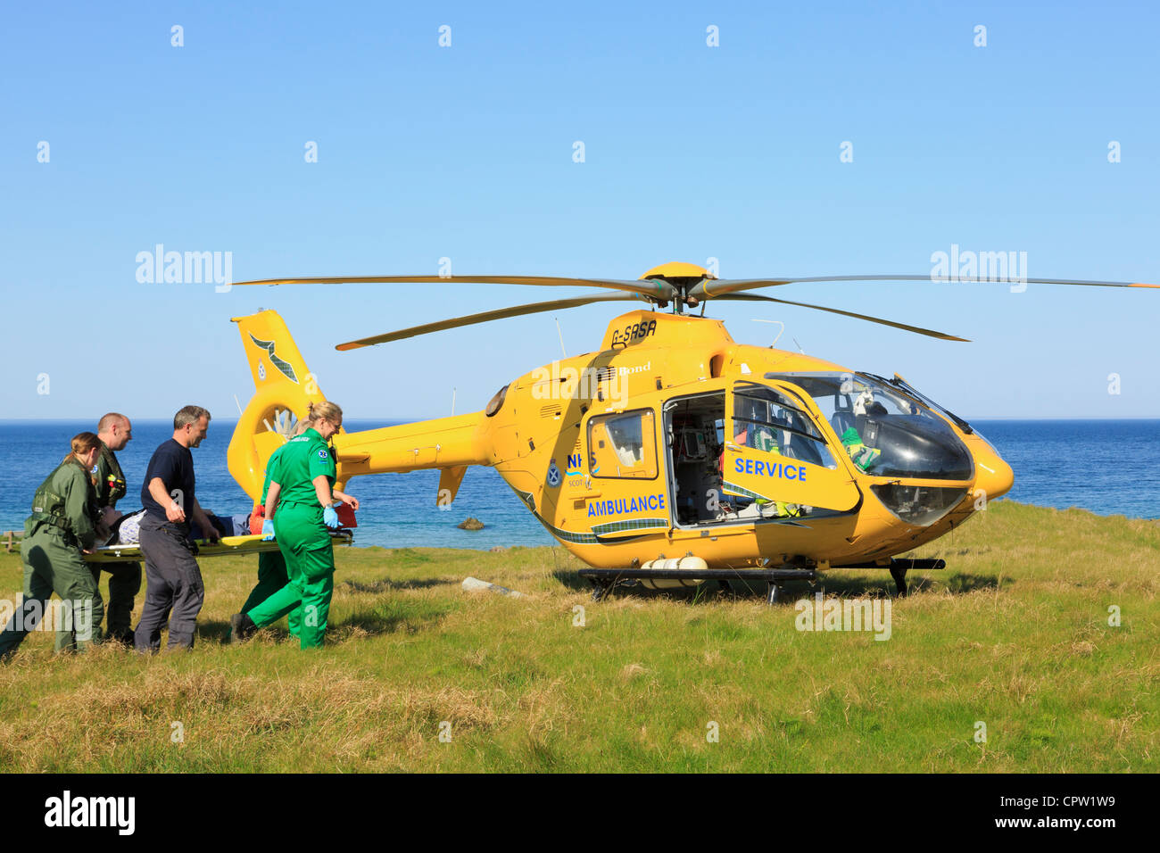 Regno Unito Scottish Air Ambulance Servizio elicottero paramedici il salvataggio di una donna su una barella sul telecomando a nord-ovest della costa delle Highlands Foto Stock
