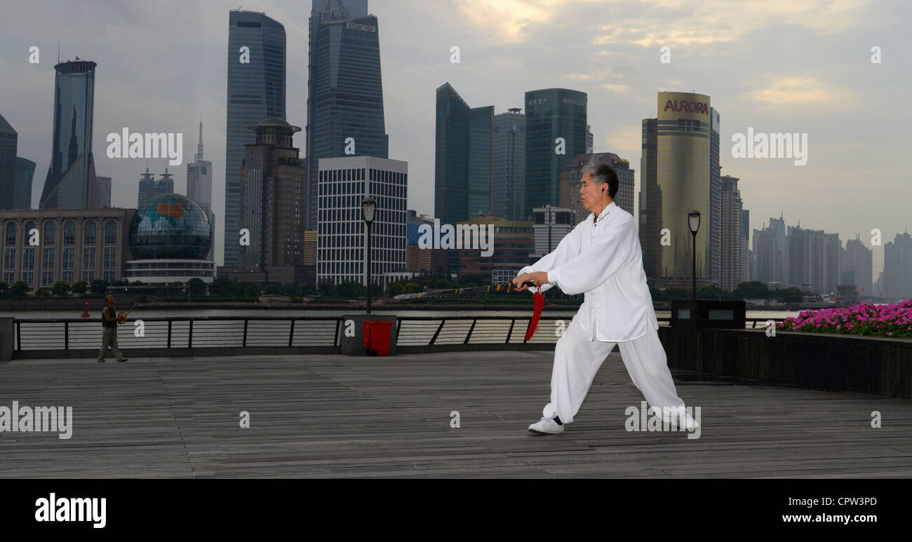 Panorama di Tai Chi sword master in bianco e kite flyer sul Bund con Pudong alte torri di mattina Shanghai Repubblica Popolare Cinese Foto Stock
