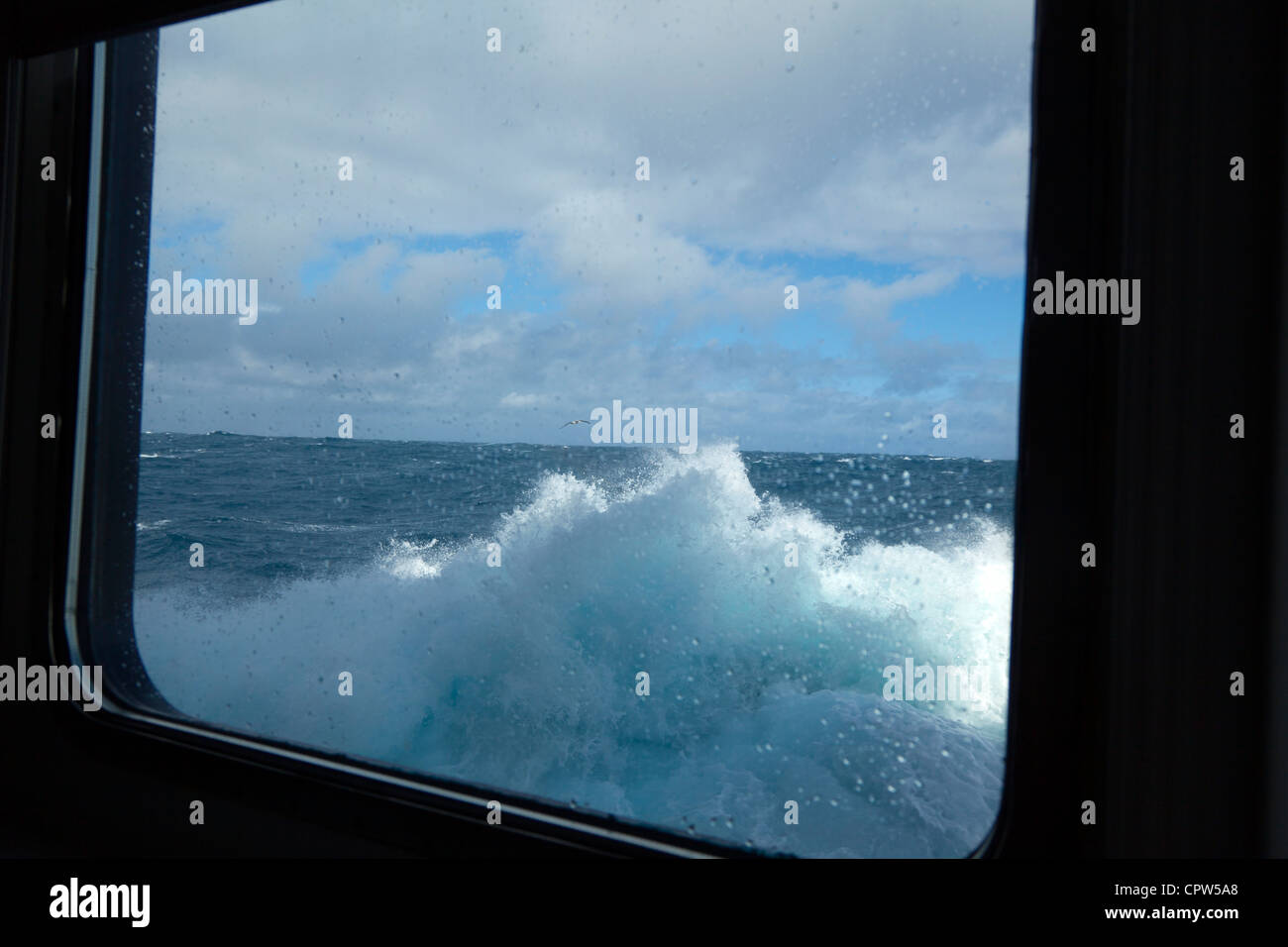 Onde che si infrangono contro oblò finestra nel Sud Atlantico Foto Stock