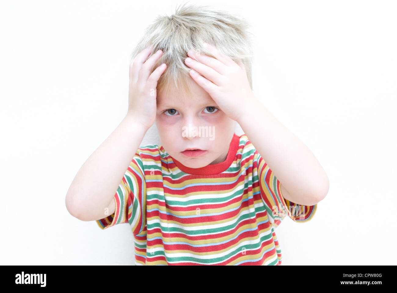 Sconvolto bambino tenendo la testa tra le mani. Foto Stock