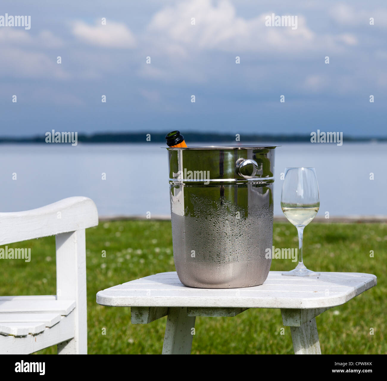 Vuota la sedia del patio e champagne nel secchiello del ghiaccio dal lato della baia di Chesapeake Foto Stock