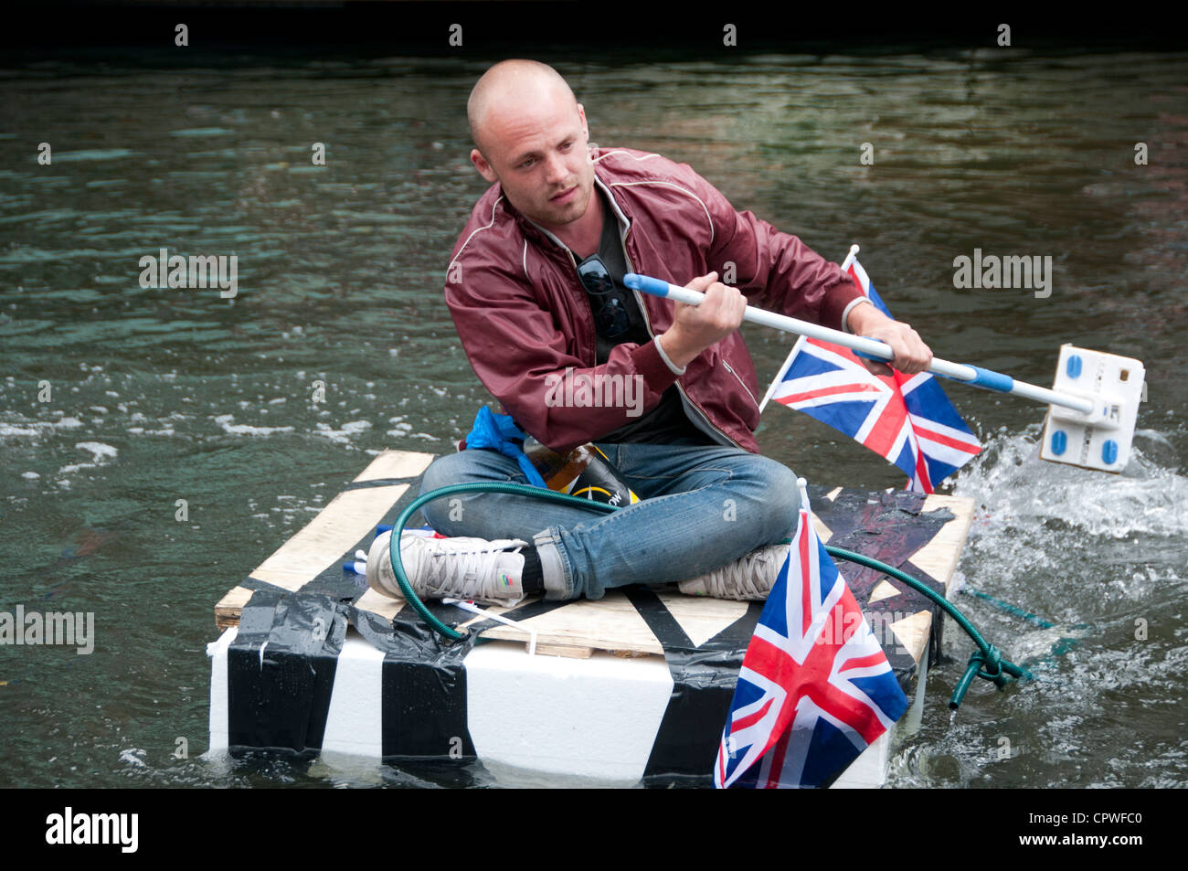 Queen's Jubillegal flottiglia parte flottante, Regent's Canal. L'uomo sul fatto in casa zattera paddling con pavimento mop Foto Stock