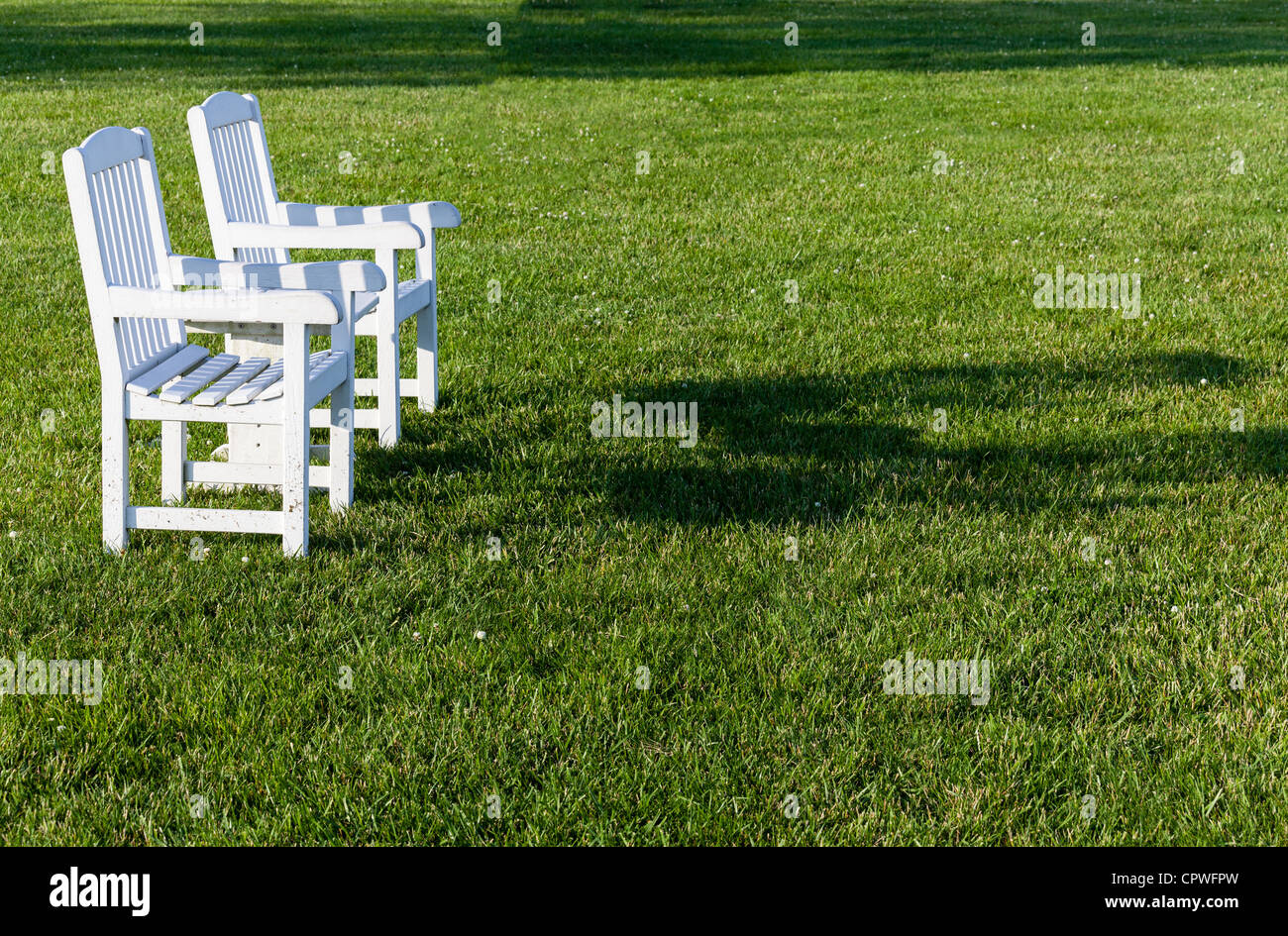 Patio vuoto sedie seduta sul prato nel tardo pomeriggio di sole Foto Stock