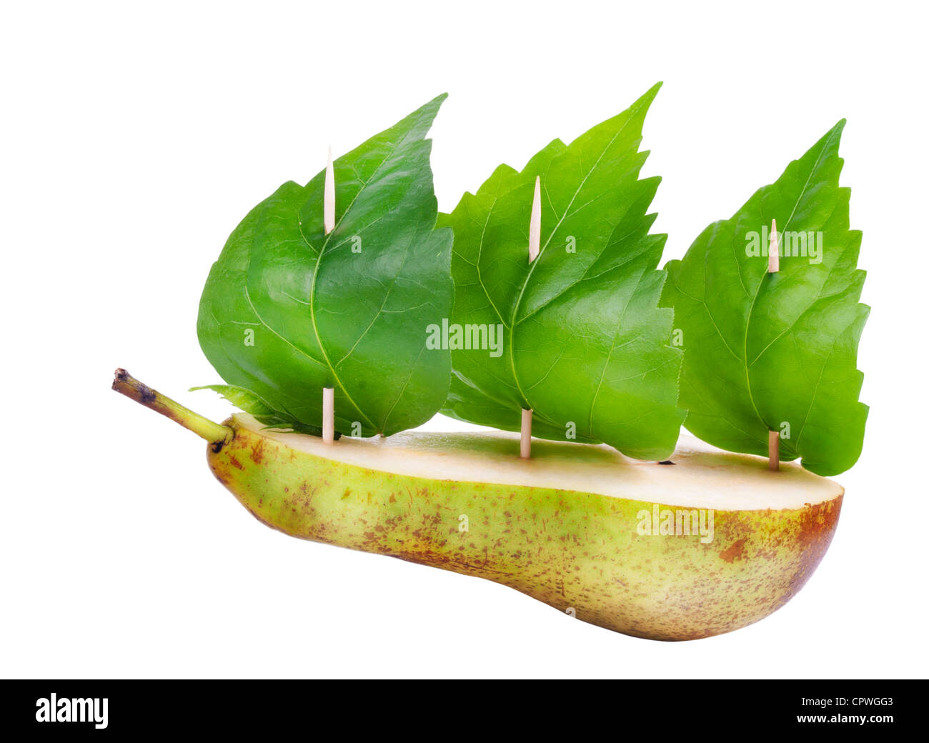 La metà di una pera, stuzzicadenti come piloni, foglie verdi come vele isolato. Verde il concetto di pace Foto Stock