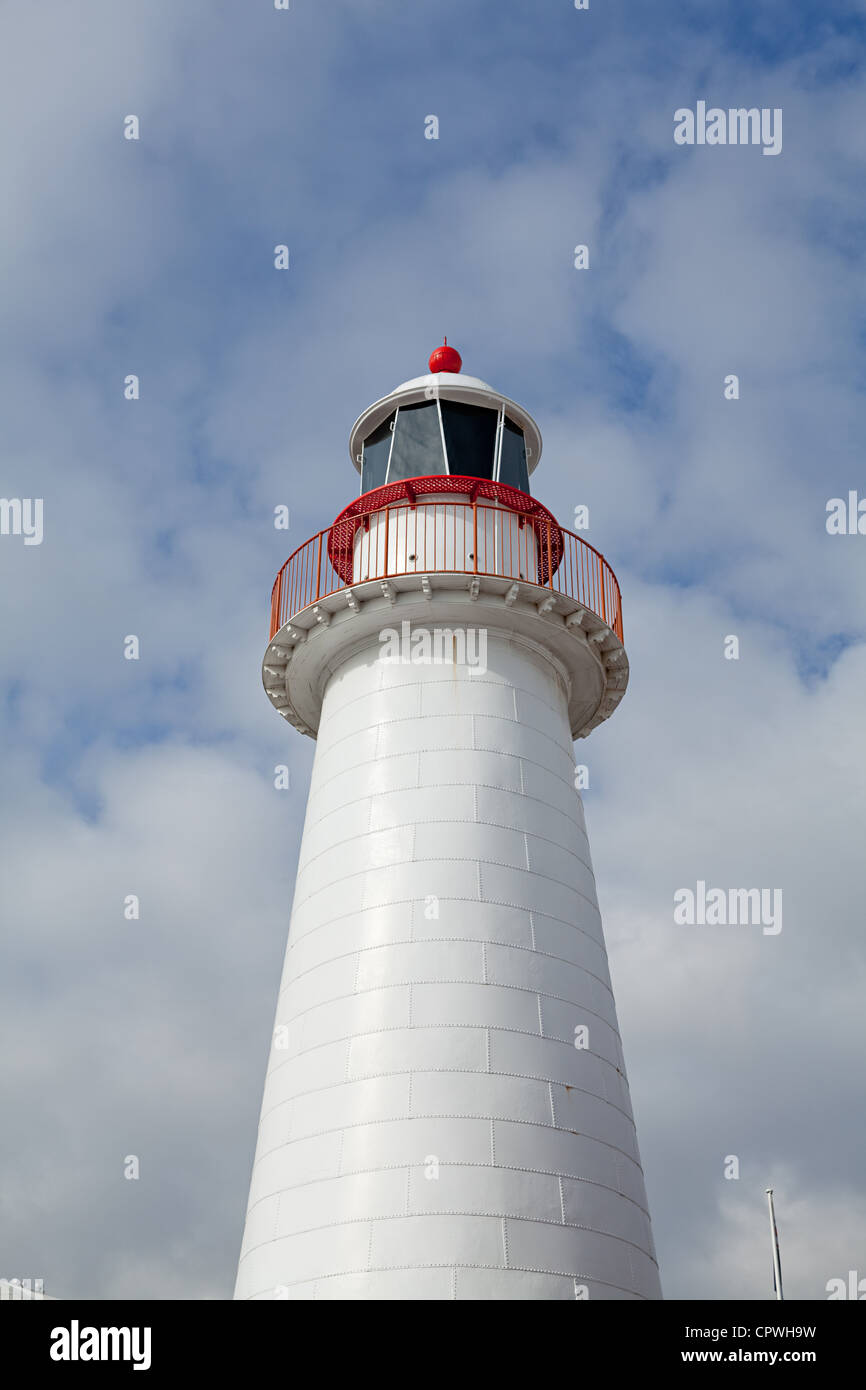 Un faro bianco contro una torbida e cielo blu nel porto di Sydney Foto Stock