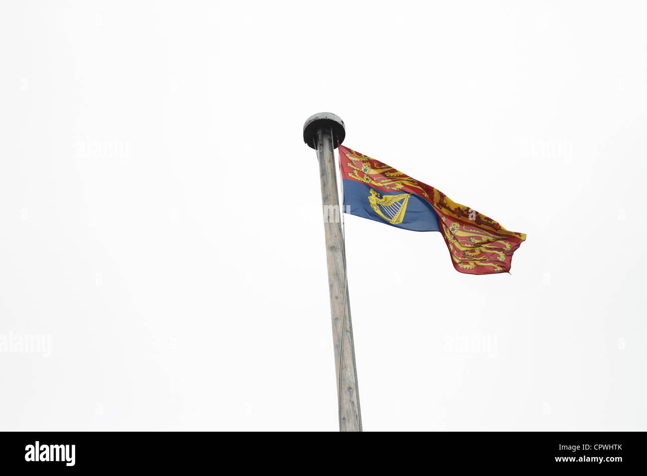 Il castello di Windsor - Royal Standard, il volo come la regina è in residenza. In Inghilterra, Galles e Irlanda del Nord e al di fuori del Regno Unito, il flag è diviso in quattro quadranti. La prima e la quarta quadranti rappresentano l'antico regno di Inghilterra e contenere tre leoni d'oro, (o "Leopardi"), passant gardant su un campo rosso; il secondo quadrante rappresenta l'antico regno di Scozia e contiene un leone rosso rampante in campo oro; il terzo quadrante rappresenta l'antico regno di Irlanda e contiene una versione dell'arpa in oro con lo stemma del Irlanda su un campo blu. Foto Stock