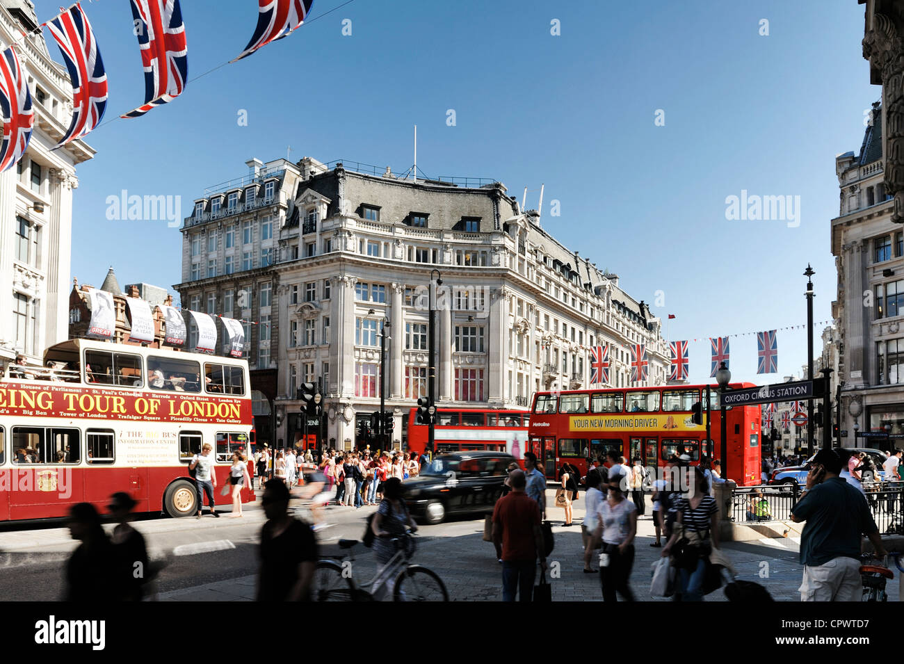 Autobus rossi di Londra e la folla di acquirenti e turisti a Oxford Circus nel centro di Londra Foto Stock