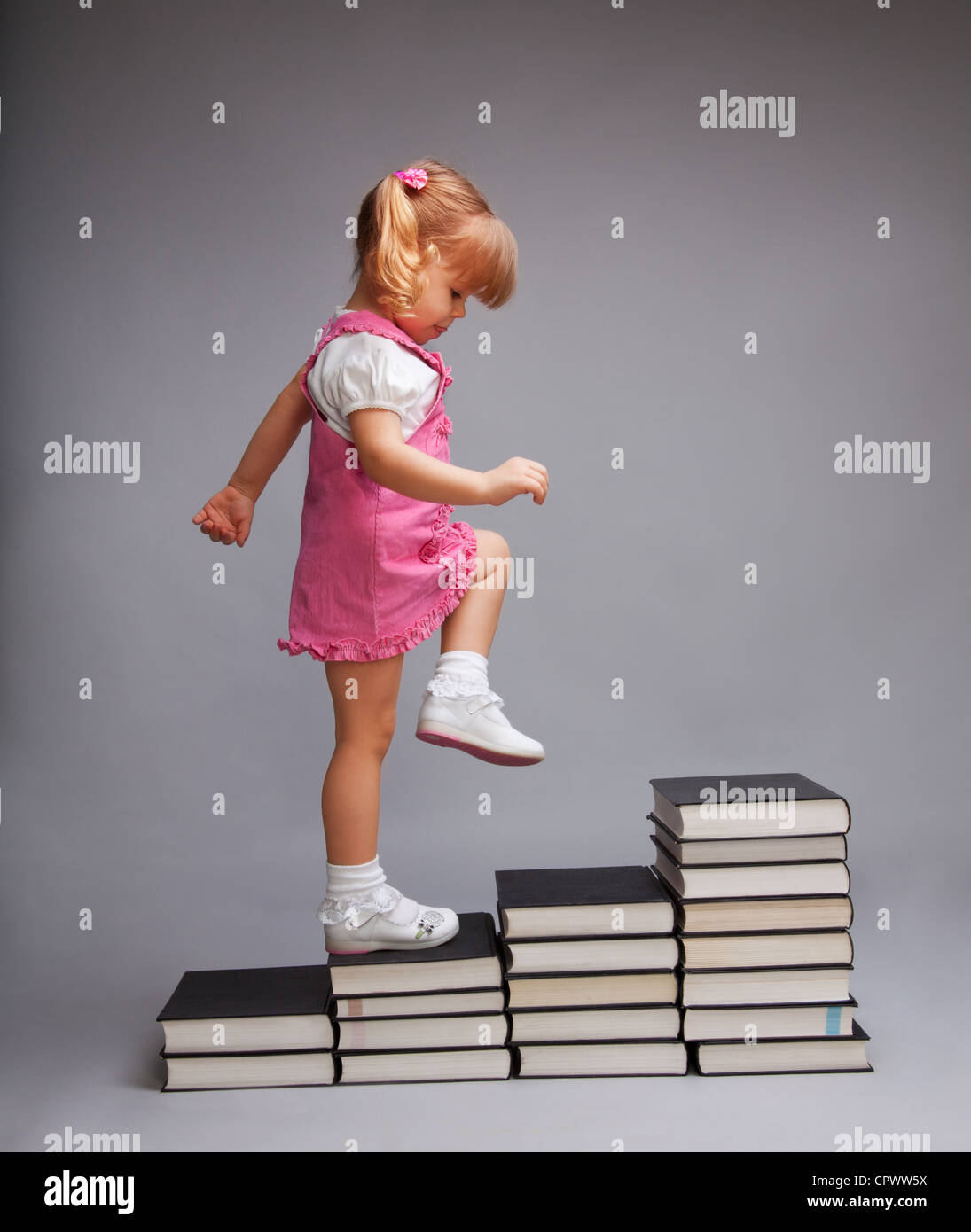 Con successo passando da un livello di istruzione di un altro - ragazza salendo le scale di libri Foto Stock