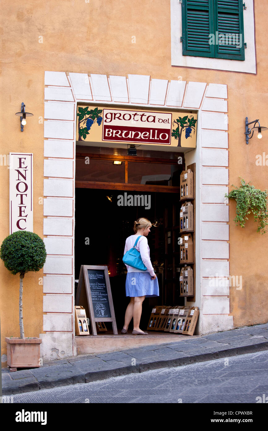 Donna tourist shopping nella grotta del vino Brunello shop nella costa di Piazza Garibaldi a Montalcino, Val d'Orcia, Toscana, Italia Foto Stock