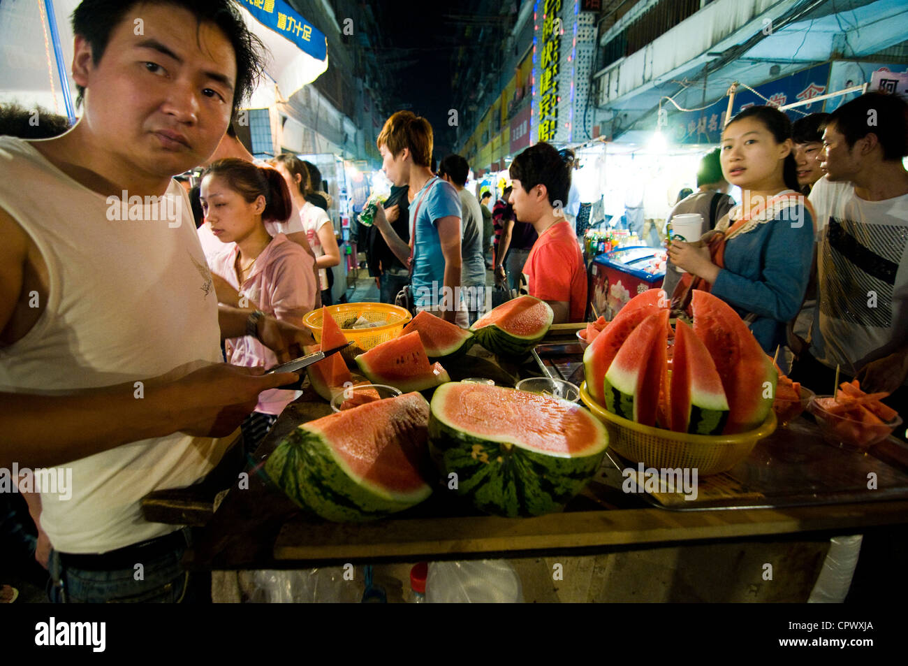 Un cocomero fornitore nel trafficato mercato notturno a Wuhan, Cina. Foto Stock