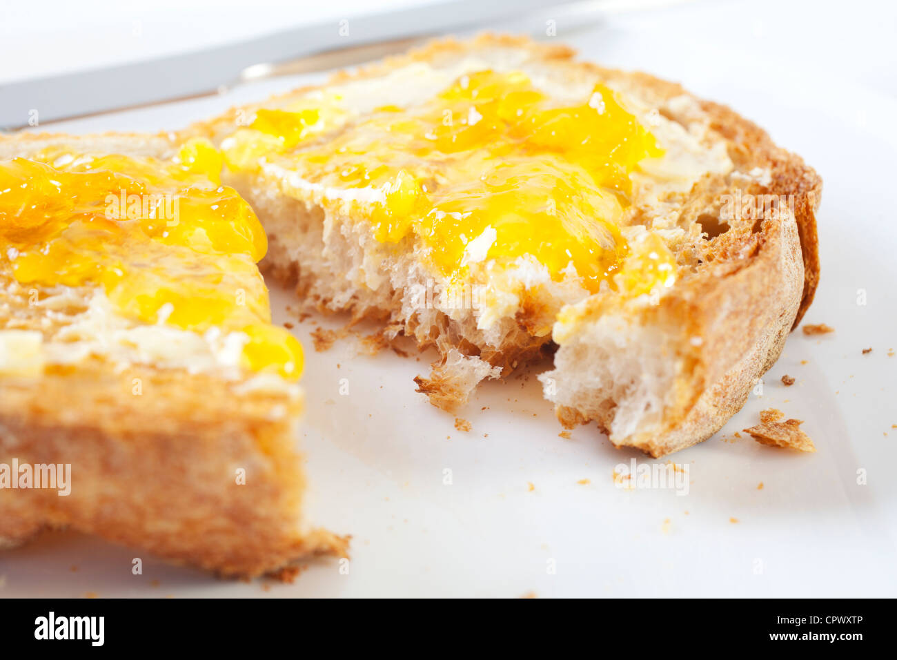 Il croccante pane tostato con marmellata di arance su una piastra bianca. Foto Stock