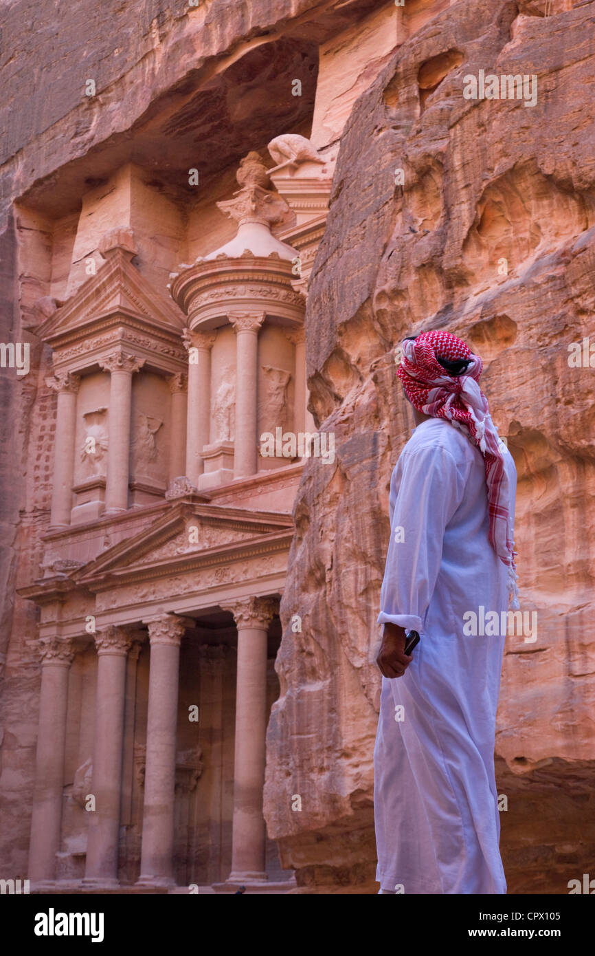 Uomo arabo guardando la facciata del Tesoro (Al Khazneh), Petra, Giordania (Patrimonio Mondiale dell'UNESCO) Foto Stock