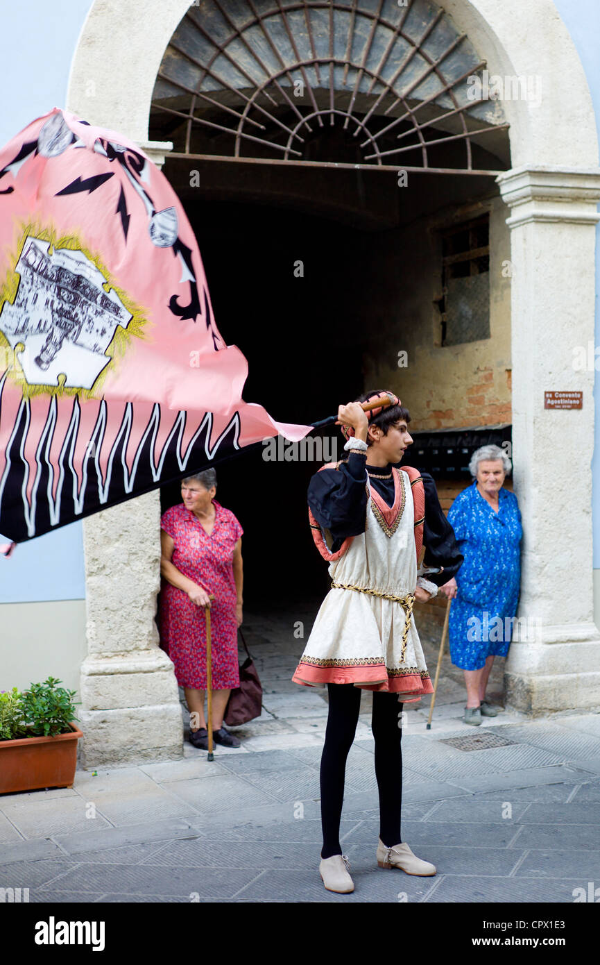 Donne locali guarda i membri del Corso Contrada in livrea in costume tradizionale sfilata di Asciano, inTuscany, Italia Foto Stock