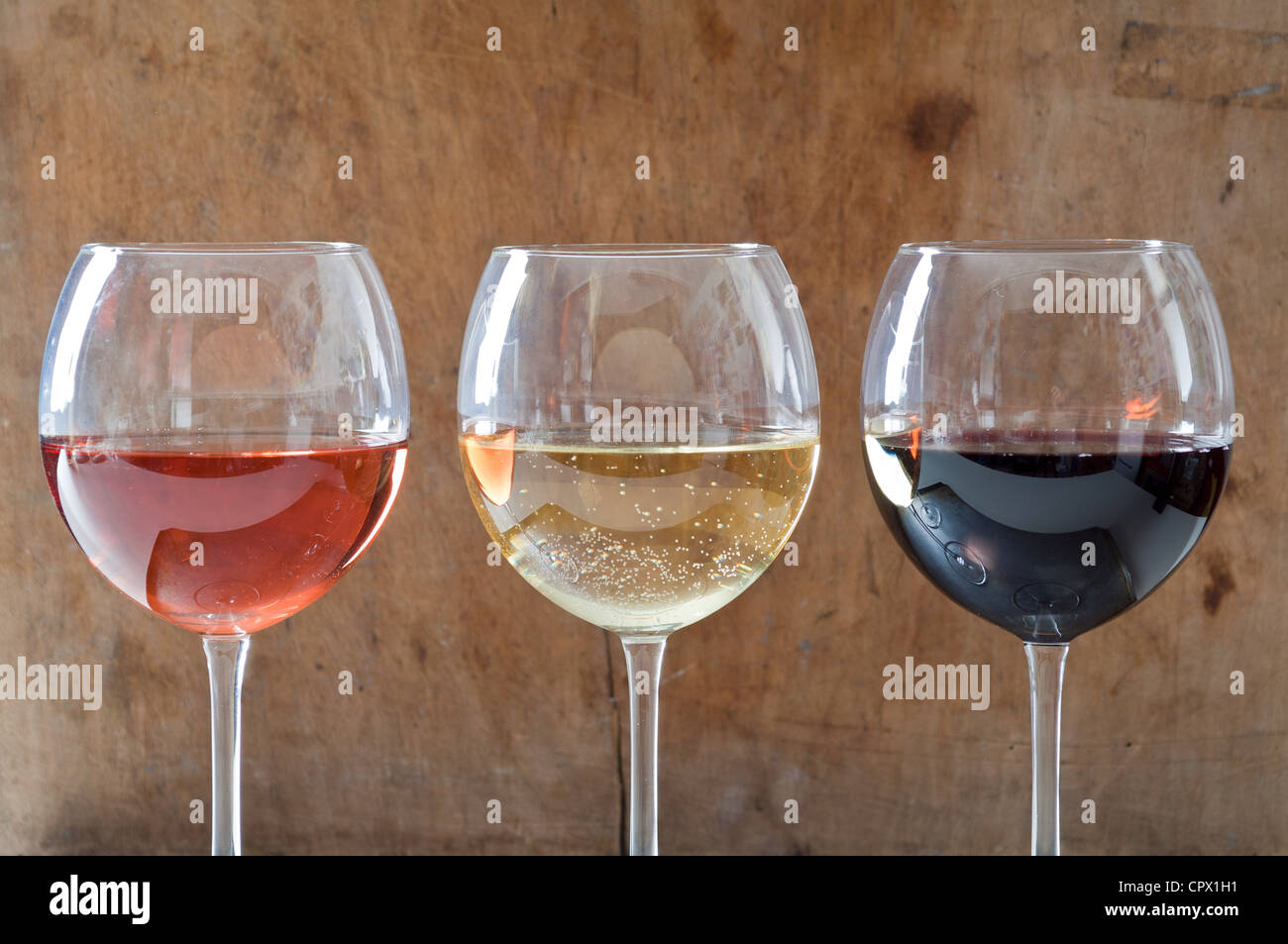 Rose, vini bianchi e rossi in bicchieri Foto Stock