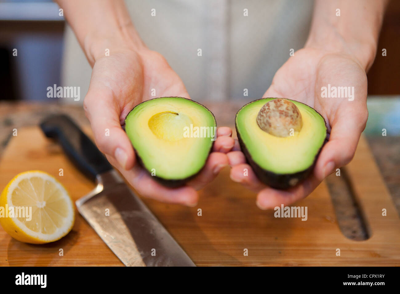 Metà donna adulta holding di avocado a fette Foto Stock