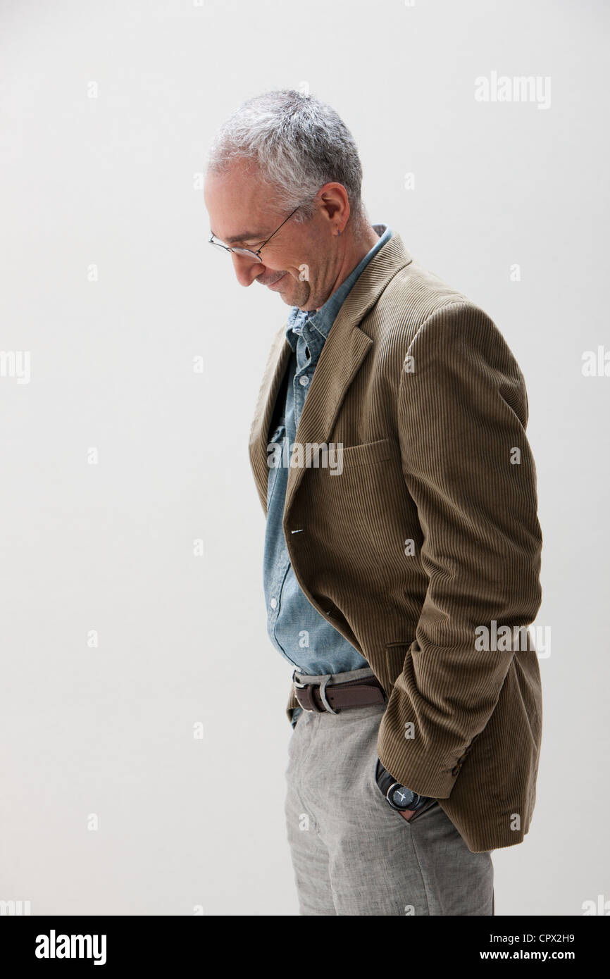 Uomo maturo con le mani in tasca guardando giù, studio shot Foto stock -  Alamy