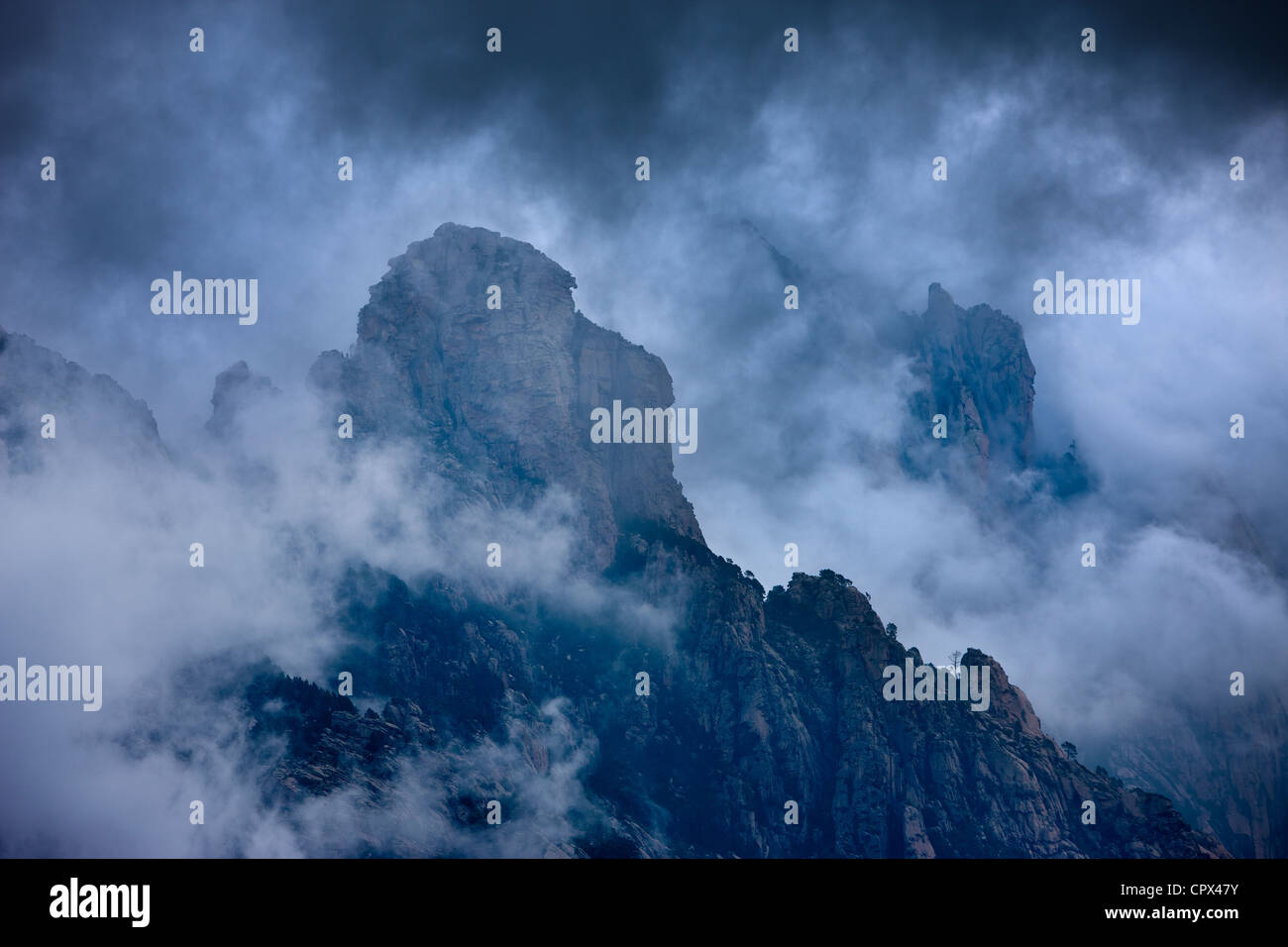 Pioggia nuvole appesa sopra il Col de Bavella, montagne di Bavella, Corsica, Francia Foto Stock