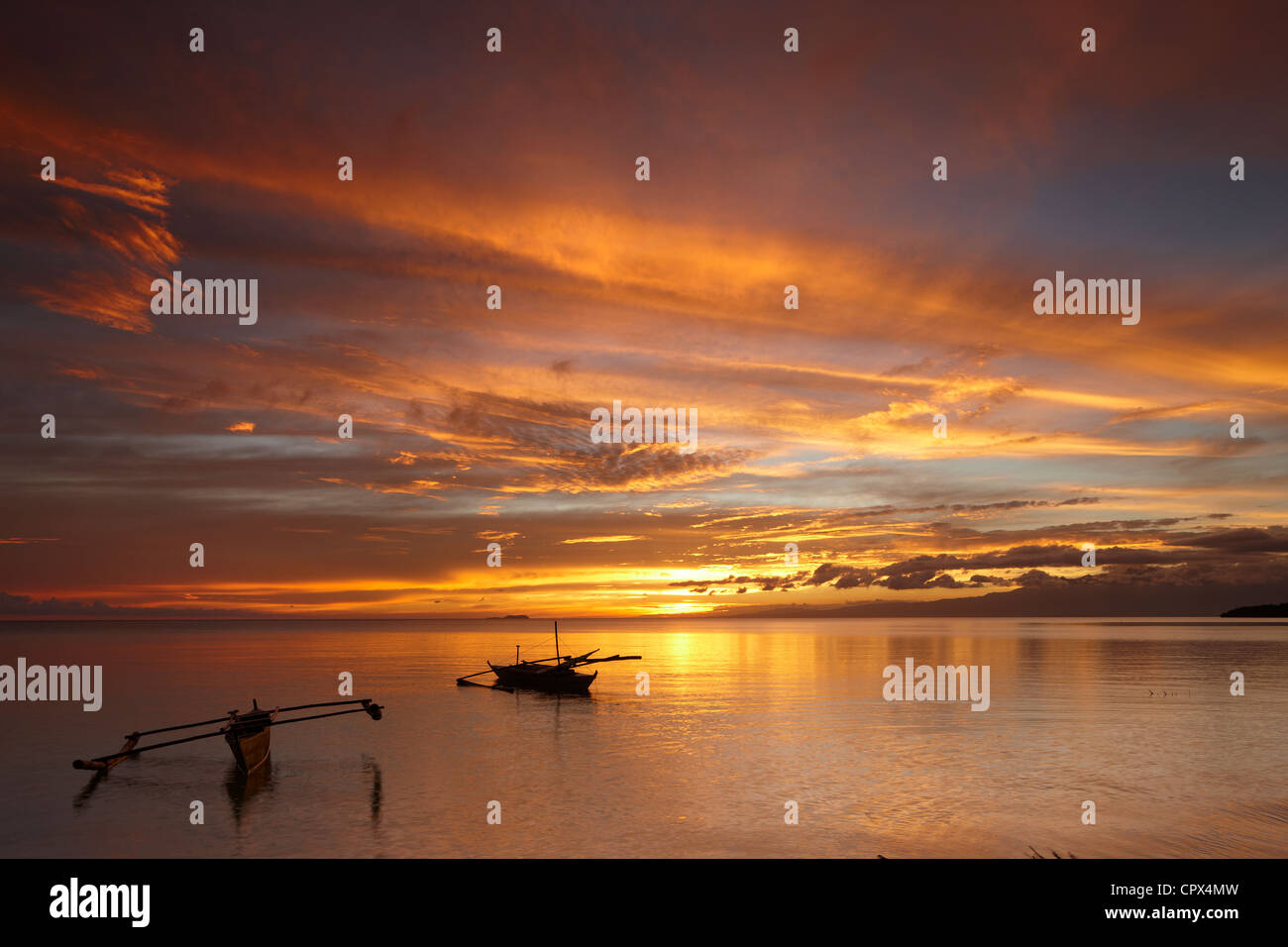 Due barche off spiaggia di San Juan al crepuscolo, Siquijor, Visayas, Filippine Foto Stock