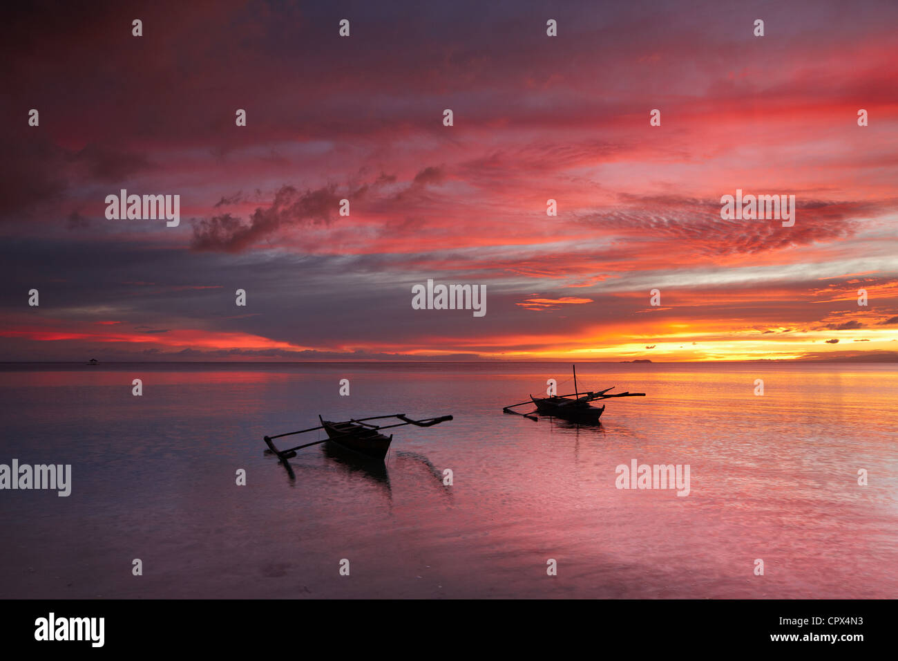 Due barche off spiaggia di San Juan al crepuscolo, Siquijor, Visayas, Filippine Foto Stock