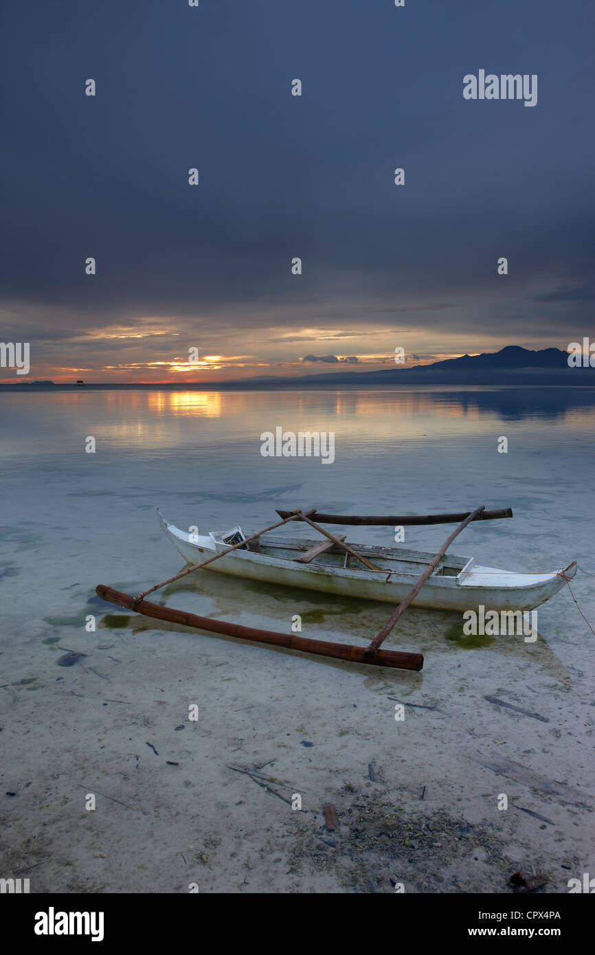 Una barca sulla spiaggia di San Juan al crepuscolo, Siquijor, Visayas, Filippine Foto Stock