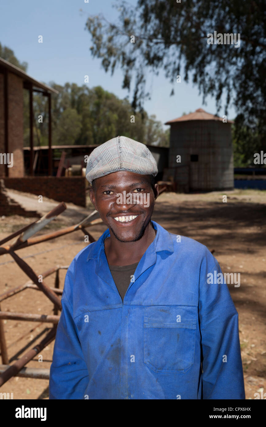 Farmworker africani in piedi all'aperto, sorridente in telecamera Foto Stock