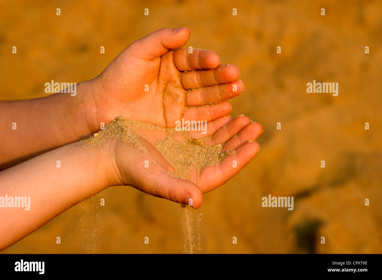 Le mani del bambino e la sabbia Foto Stock