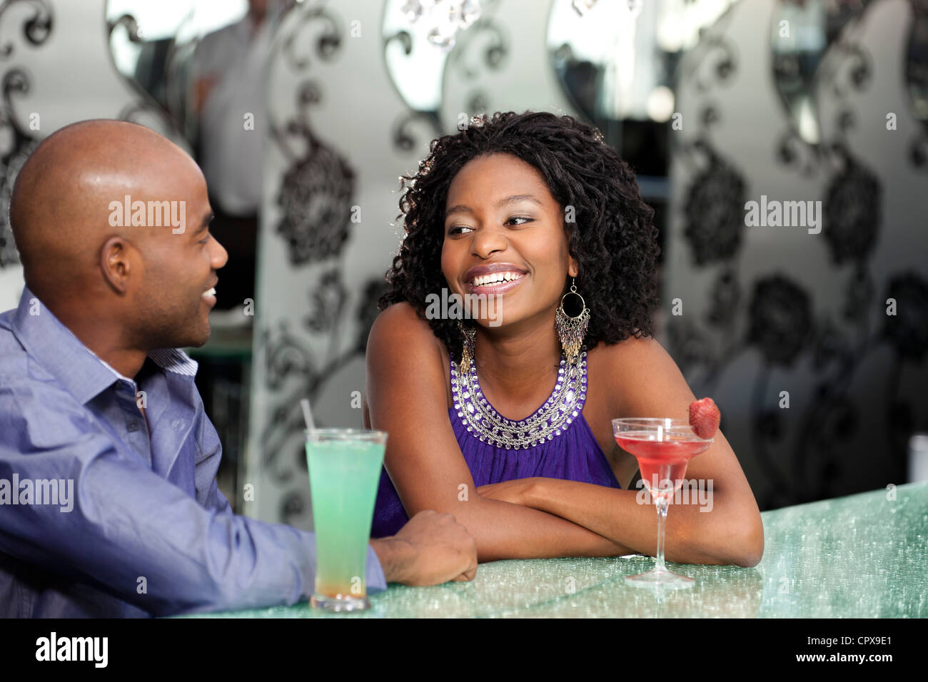 Giovane nero giovane gustando un cocktail, chat Foto Stock