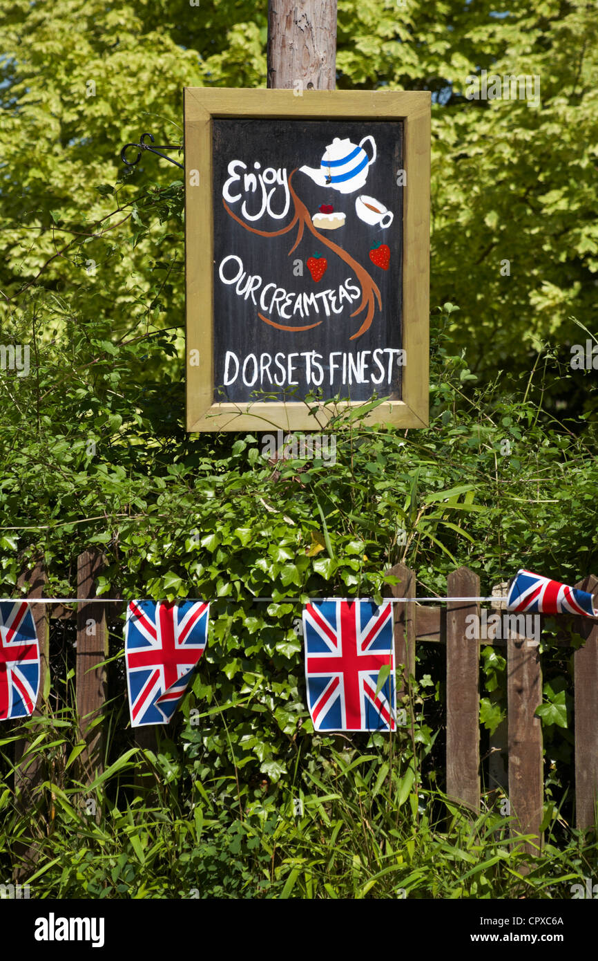 Godetevi il nostro tè crema Dorset più raffinati di segno blackboard avviso per la regina il Sessantesimo giubileo di diamante a Corfe Castle, Dorset Regno Unito nel mese di maggio Foto Stock