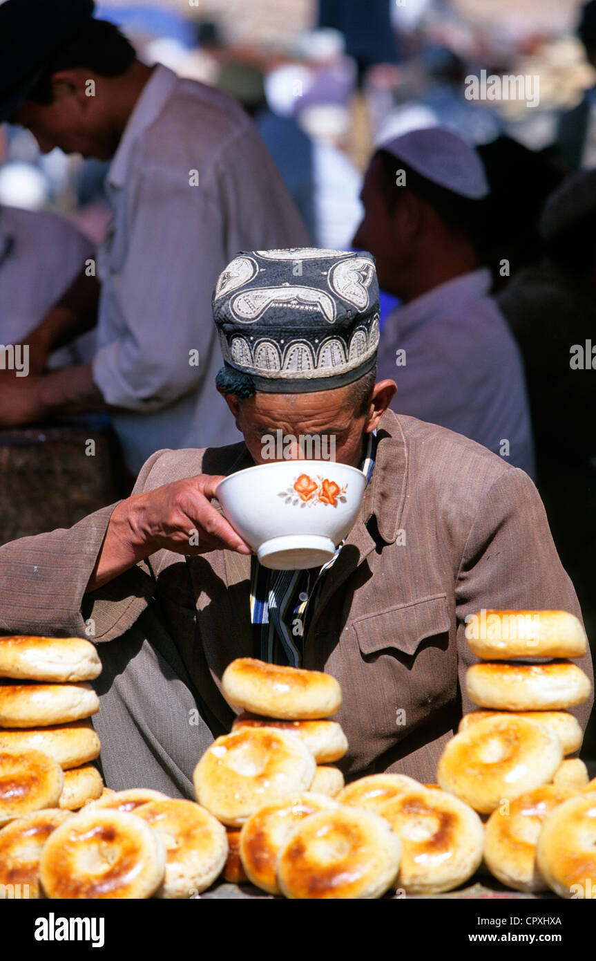 Cina provincia dello Xinjiang Kashgar Kashi città vecchia bazaar popolazione Ouigour Domenica delle vendite sul mercato del pane cotto a vapore in stand di Foto Stock