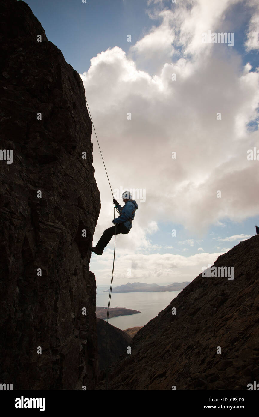 Gli alpinisti la discesa in corda doppia dalla vetta del pinnacolo inaccessibile sul Sgurr Dearg nelle montagne Cuillin, Foto Stock