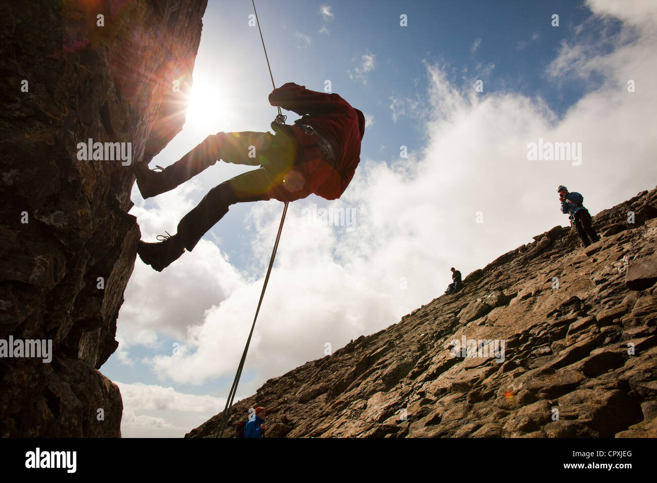 Gli alpinisti la discesa in corda doppia dalla vetta del pinnacolo inaccessibile sul Sgurr Dearg nelle montagne Cuillin, Foto Stock