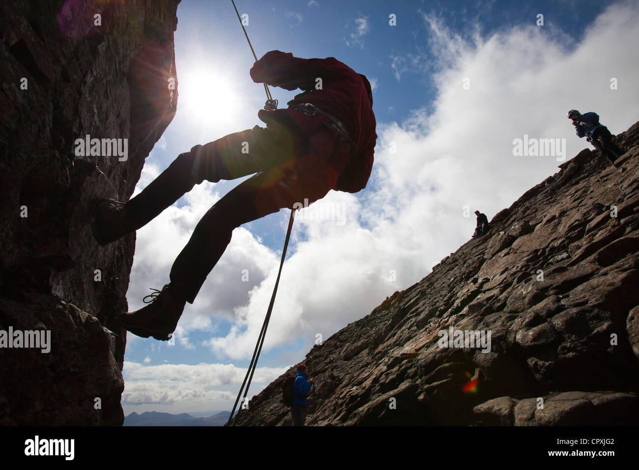 Gli alpinisti la discesa in corda doppia dalla vetta del pinnacolo inaccessibile sul Sgurr Dearg nelle montagne Cuillin, Foto Stock