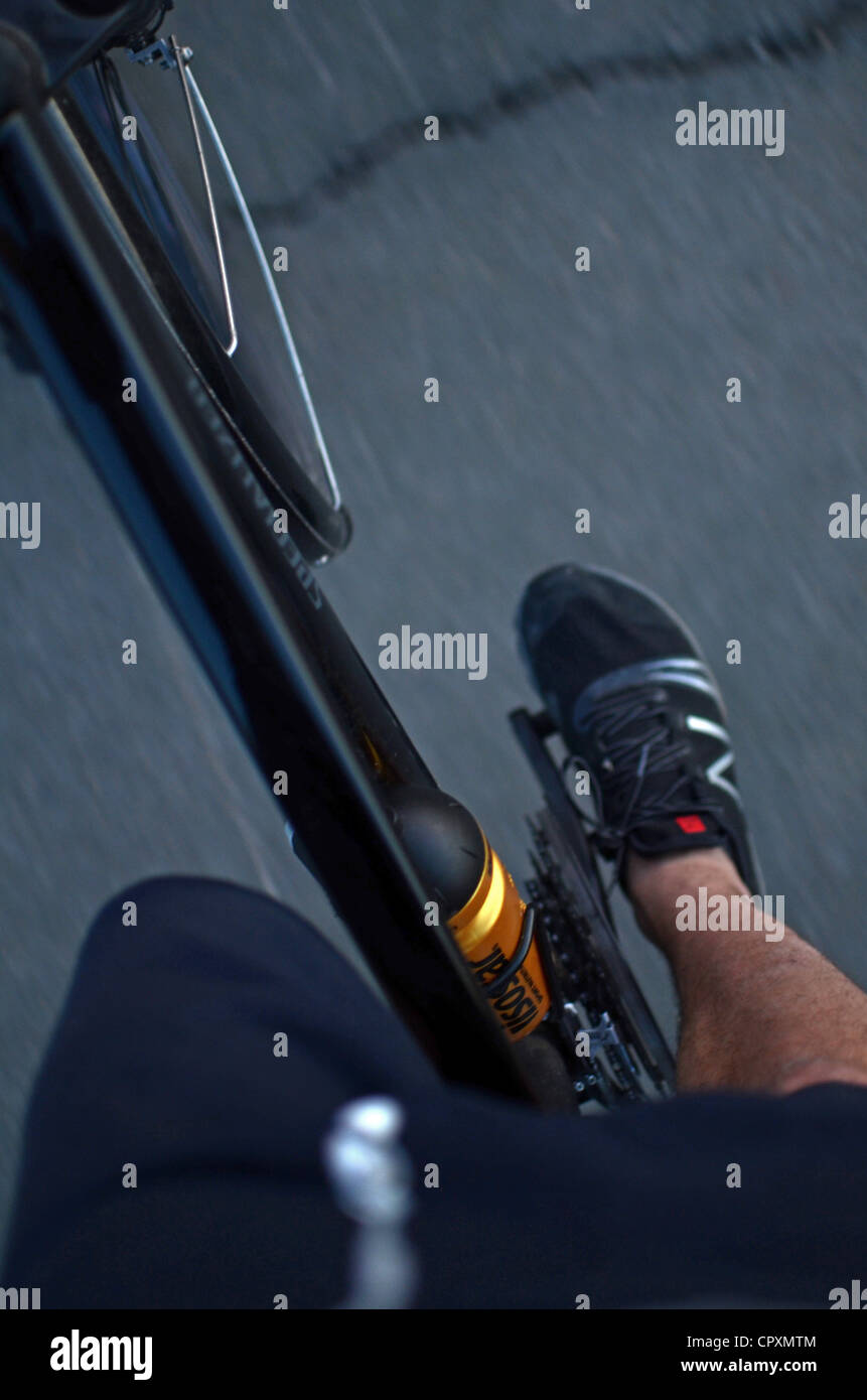 Giovane maschio cavalca la sua bicicletta ibrida Foto Stock