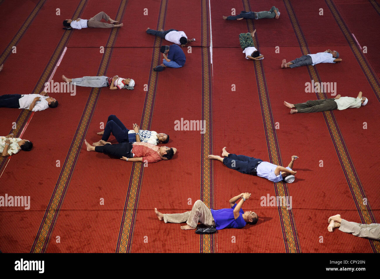 La gente è sdraiato sul pavimento a Moschea Istiqlal a Jakarta, Indonesia Foto Stock