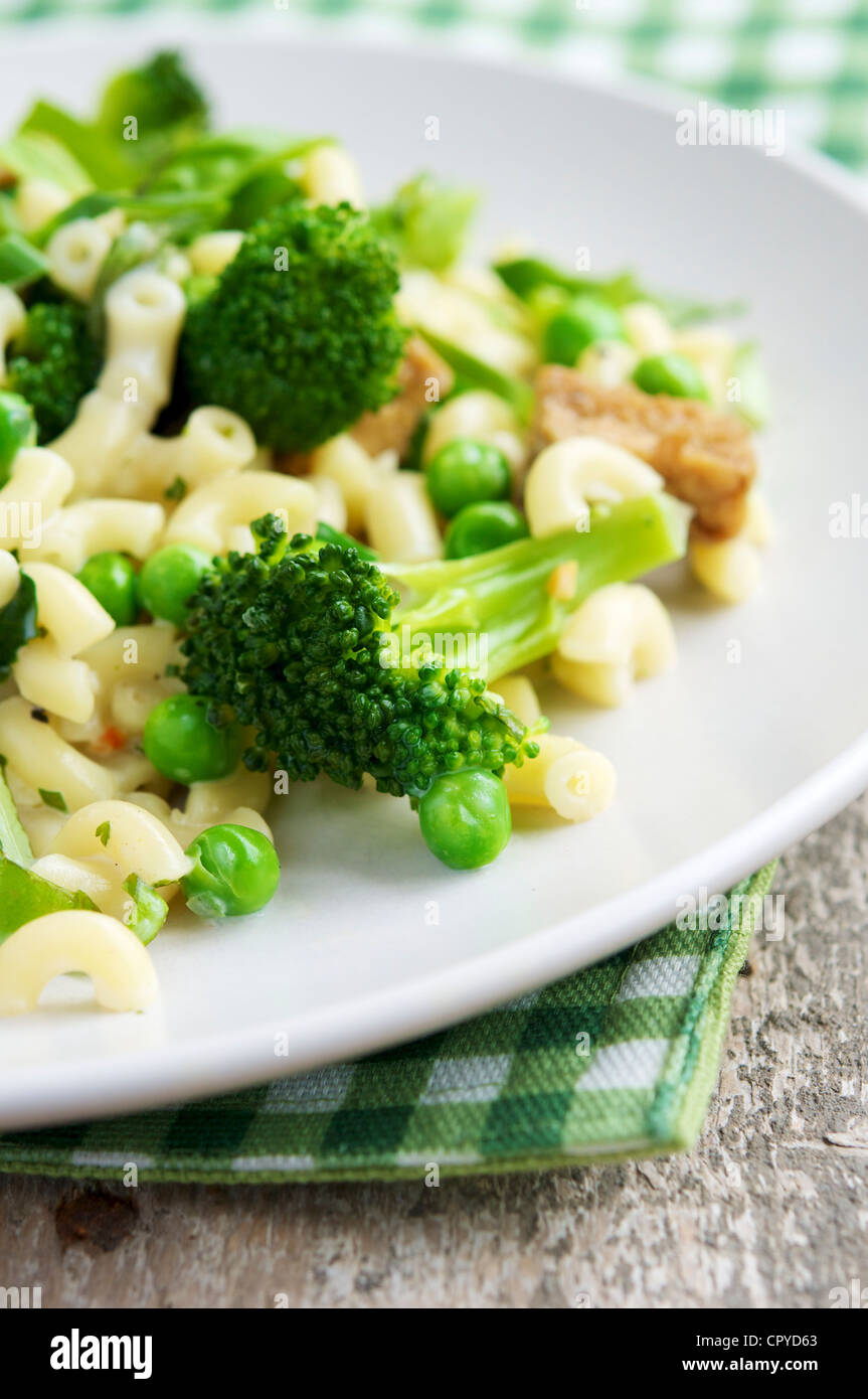 Questo pasto con maccheroni, broccoli, piselli e tofu affumicato può essere goduto come un pasto principale ma potrebbe anche funzionare bene come insalata. Foto Stock